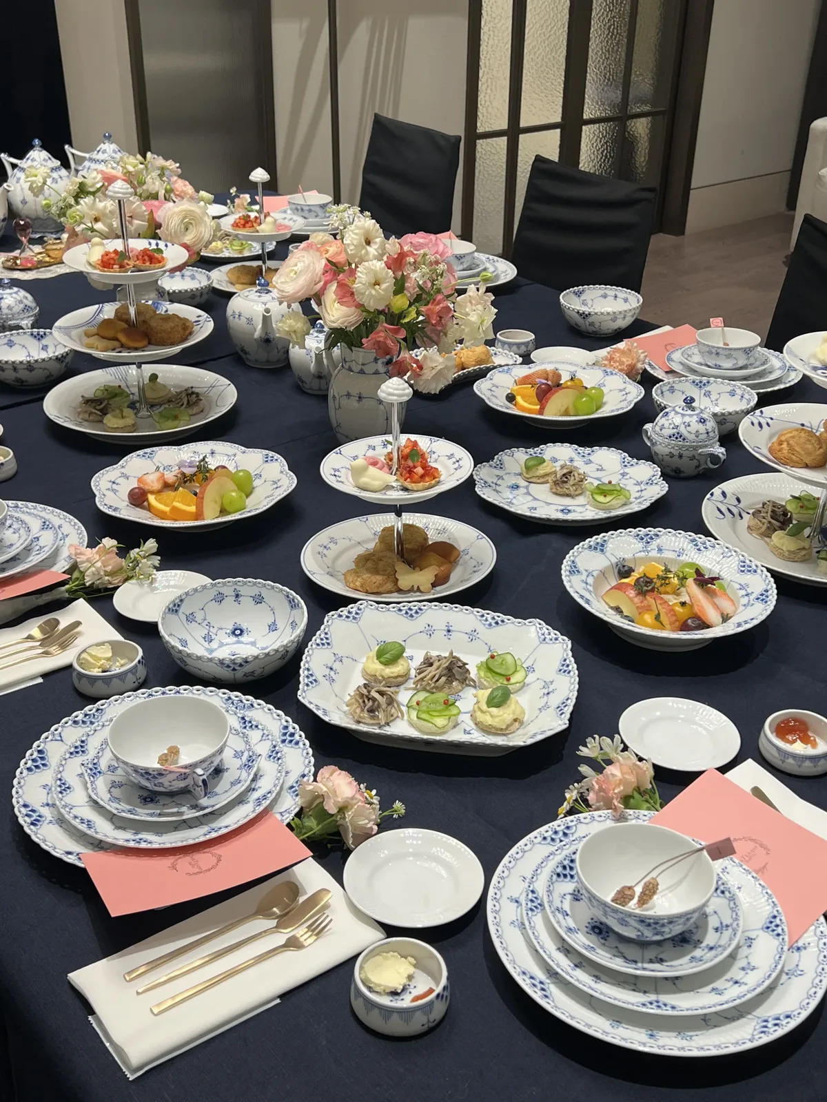 커플 티클래스 네이비 테이블보 위에 푸른 무늬 도자기와 디저트 접시, 꽃장식이 놓인 세팅